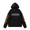 AMIRI Black/White Hoodie With Bold Logo And Orange Graphic Sleeves For Streetwear Style #A54282